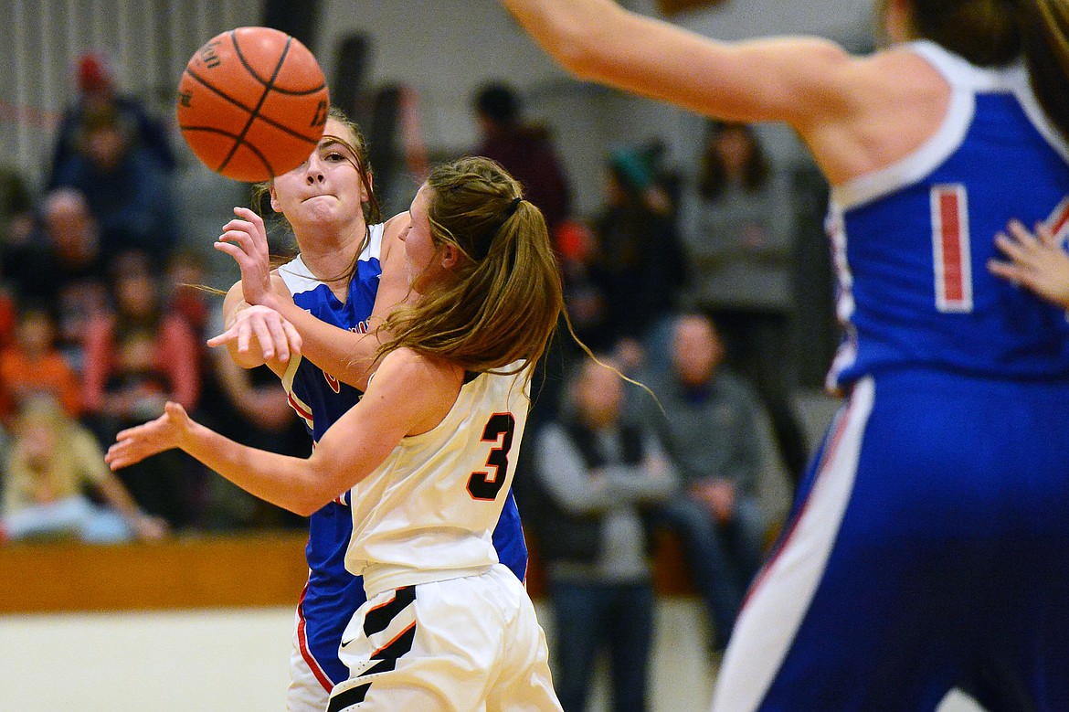 Columbia Falls' LaKia Hill (12) looks to pass with Flathead's Sadie Wilson (3) defending at Flathead High School on Saturday. (Casey Kreider/Daily Inter Lake)