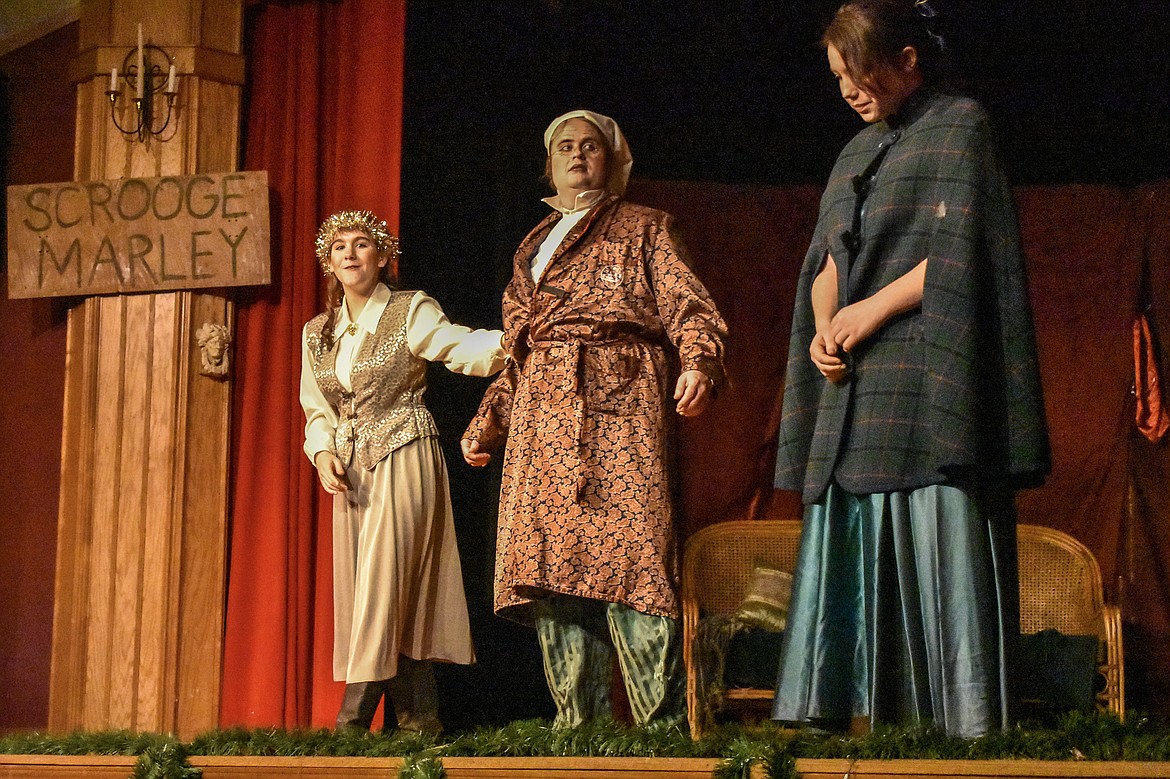 Jenna Hammond, as The Spirit of Christmas Past, shows Scrooge, played by Raymond Miller, his former fiance Belle, played by Suvari Neff, during the Pitiful Players production of A Christmas Carol at the K.W. Maki Theatre Sunday. (Ben Kibbey/The Western News)