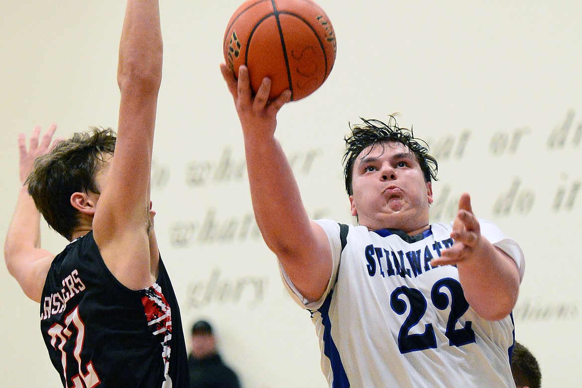 Stillwater Christian's Jeremiah Hooker (22) drives to the hoop with Flathead Valley Homeschool's Bubba Loyda (22) defending at Stillwater Christian School on Friday. (Casey Kreider/Daily Inter Lake)