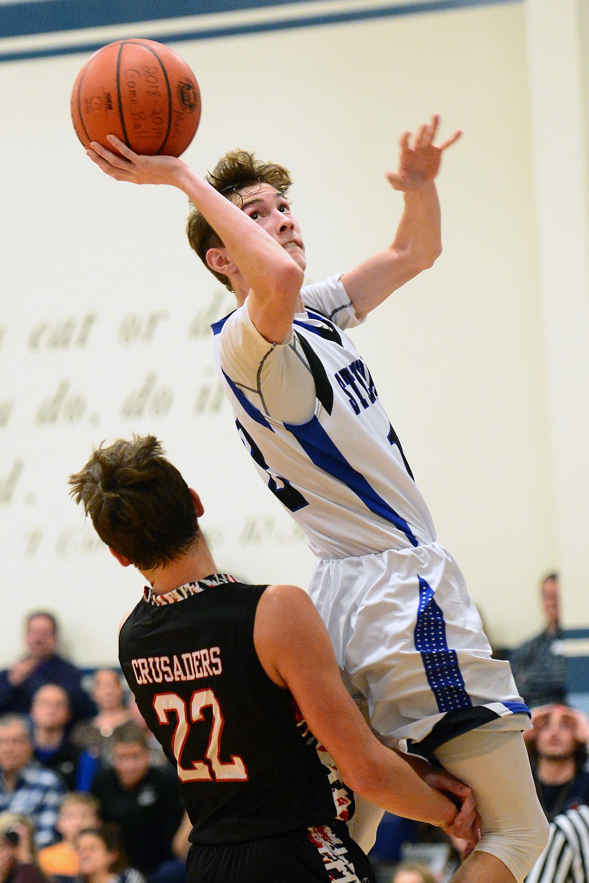 Flathead Valley Homeschool's Bubba Loyda (22) draws a charge on Stillwater Christian's Nicholas Sulzbacher (12) at Stillwater Christian School on Friday. (Casey Kreider/Daily Inter Lake)