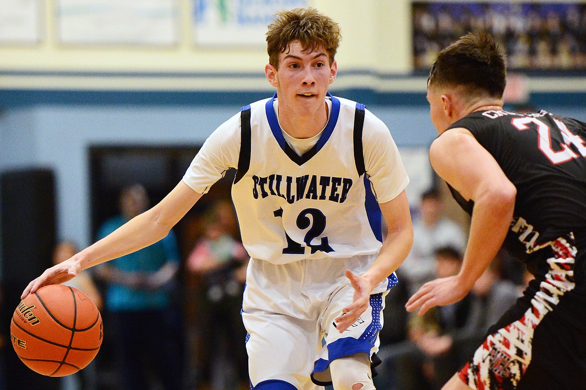 Stillwater Christian's Nicholas Sulzbacher (12) brings the ball upcourt with Flathead Valley Homeschool's Spencer Burden (24) defending at Stillwater Christian School on Friday. (Casey Kreider/Daily Inter Lake)