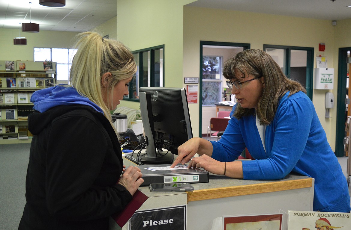 Carrie Nelson (right) a staff member of FVCC's library tech services, answers questions for student Talysssa Hatton, 27, in the campus library. //photo by Mary Cloud Taylor