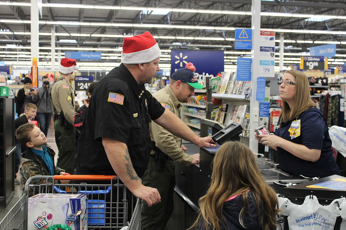 Photo by CHANSE WATSON
Officers and deputies with local agencies treated 60 kids to a mini-shopping spree at Walmart in Smelterville for the Shop-with-a-Cop program.