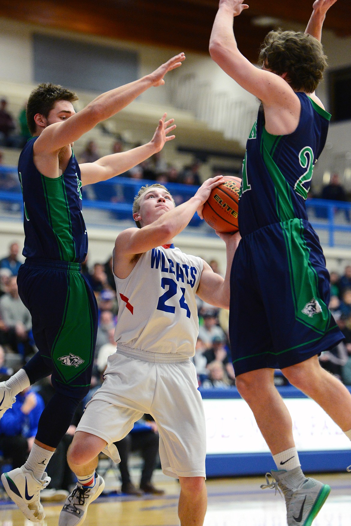 Columbia Falls' Logan Bechtel (24) drives to the basket between Glacier's K.J. Johnson (10) and Kyle Buckingham (21) at Columbia Falls High School on Thursday. (Casey Kreider/Daily Inter Lake)