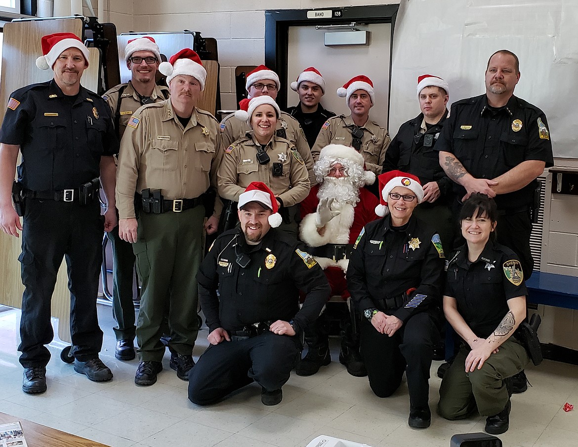 Photo by HEATHER COWAN
Law enforcement poses with Santa Claus following the first day of Shop-with-a-Cop.