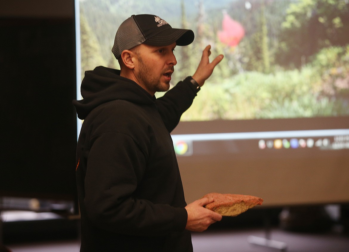 Kjell Truesdell, an Idaho Department of Lands fire warden for the Cataldo district, holds a rock with fire retardant as he speaks to a group of eighth-graders about wildland fire safety and procedures Monday afternoon at Post Falls Middle School. (LOREN BENOIT/Press)