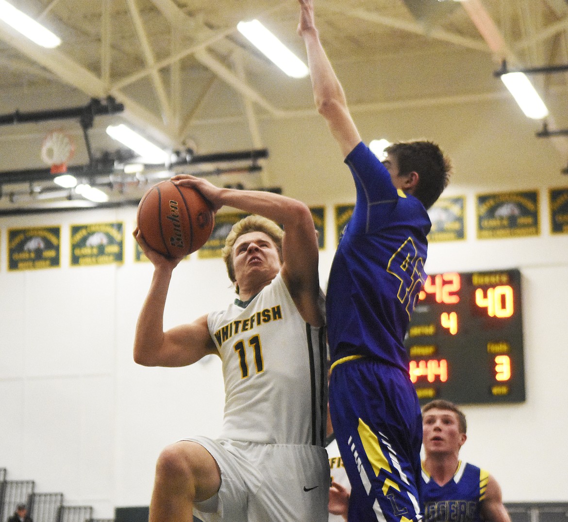 Mark Anderson fights off a defender for the layup in Friday&#146;s home win over Libby. (Daniel McKay/Whitefish Pilot)