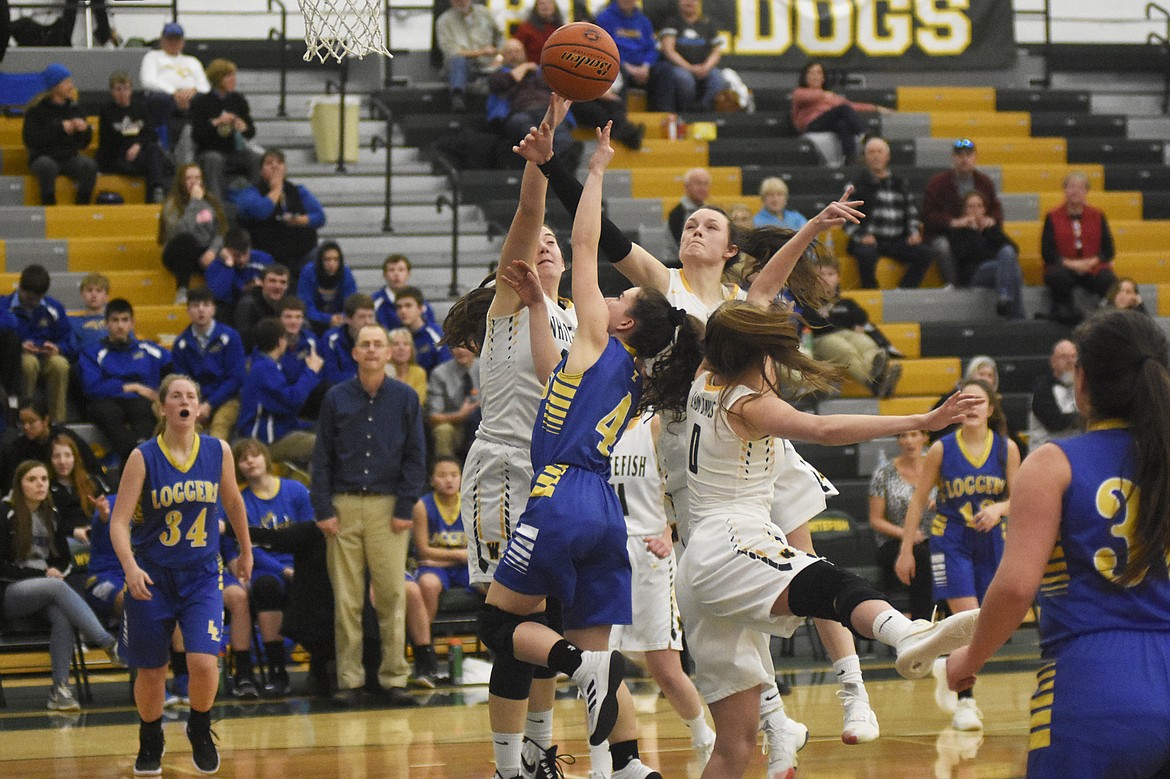 A pack of Lady Bulldogs swarm a Libby player during Friday's home loss to the Lady Loggers. (Daniel McKay/Whitefish Pilot).