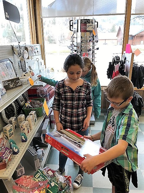 Superior fourth-graders Cami Quick and Brayden Goldman look at model sets. Their class raised funds to buy Christmas gifts for local families in need. (Photo courtesy of Mrs. Crabb)