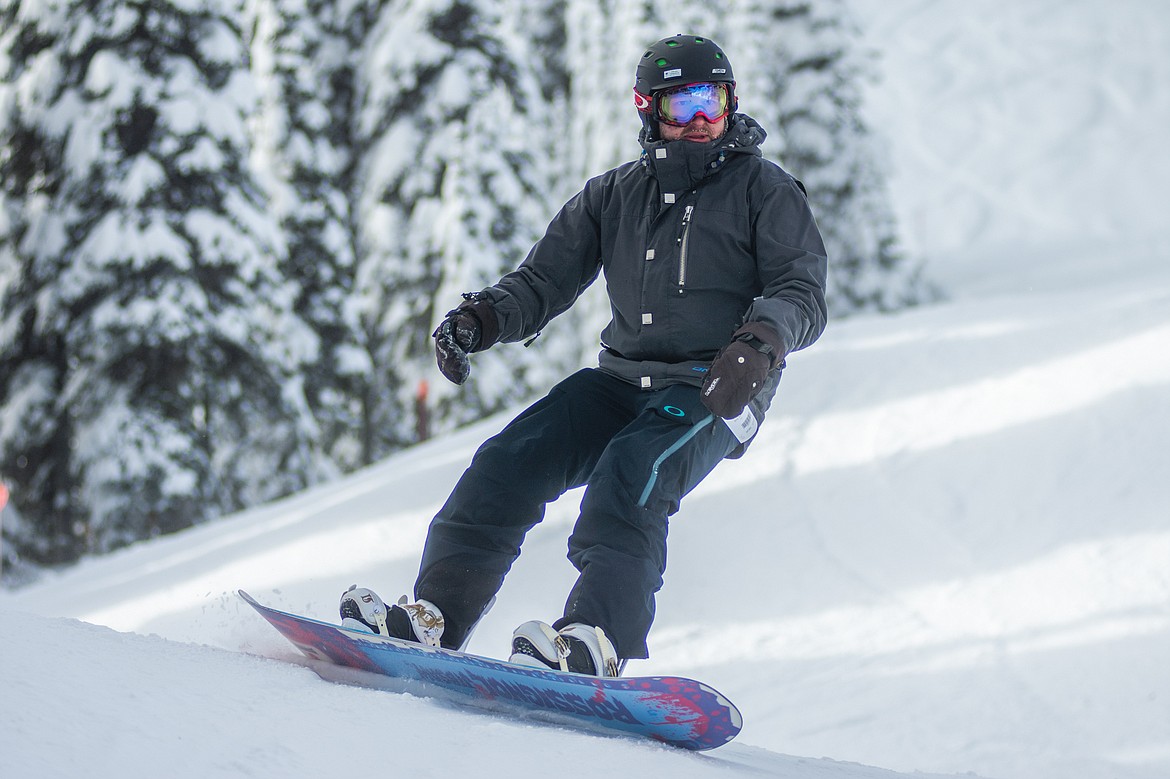 A snowboarder carves his way down to Chair 5 during opening day at Whitefish Mountain Resort.