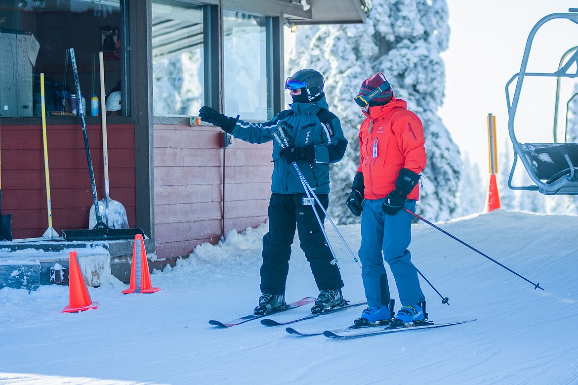 Two skiers glide off the lift at Big Mountain&#146;s summit during opening day at Whitefish Mountain Resort.