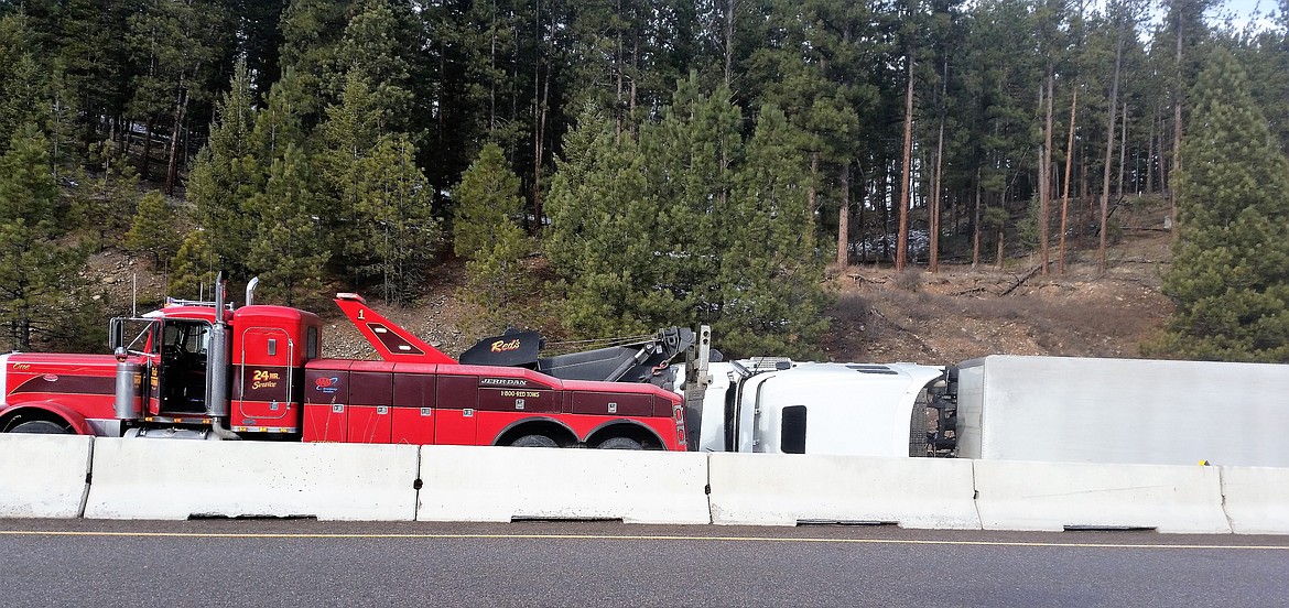 A semi-truck flipped on its side after hitting icy roads near Nine-Mile on Dec. 12. The passengers only sustained minor injuries and were taken to the hospital. Red&#146;s Towing pulled the truck off the westbound lane by early afternoon. (Kathleen Woodford/Mineral Independent)