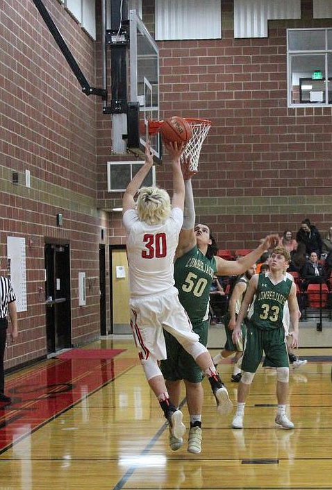 Photo by LES MCPHAIL
Logan Hull pulls up for a jumper over St. Maries’ Dan Howard during the Miners overtime win on Friday.