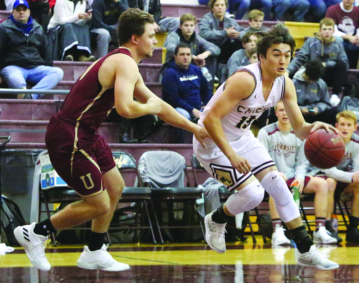 Connor Vanderweyst/Columbia Basin Herald
Moses Lake guard Evan McLean drives past University's defense Friday at Moses Lake High School.