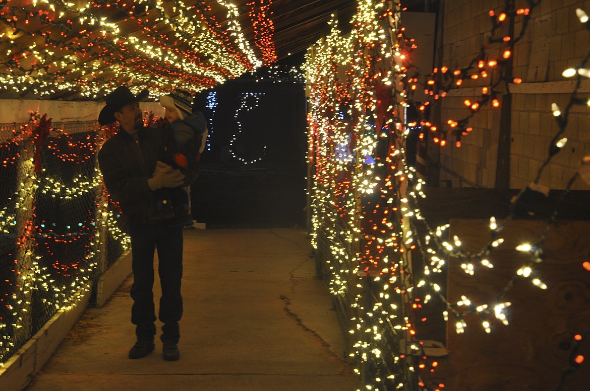 Wes Thomas and Wyatt, 2, of Ronan walk through a &#145;candy cane&#146; display at the Lake County Fairgrounds in Ronan Saturday evening during Lights Under The Big sky. (Ashley Fox/Lake County Leader)