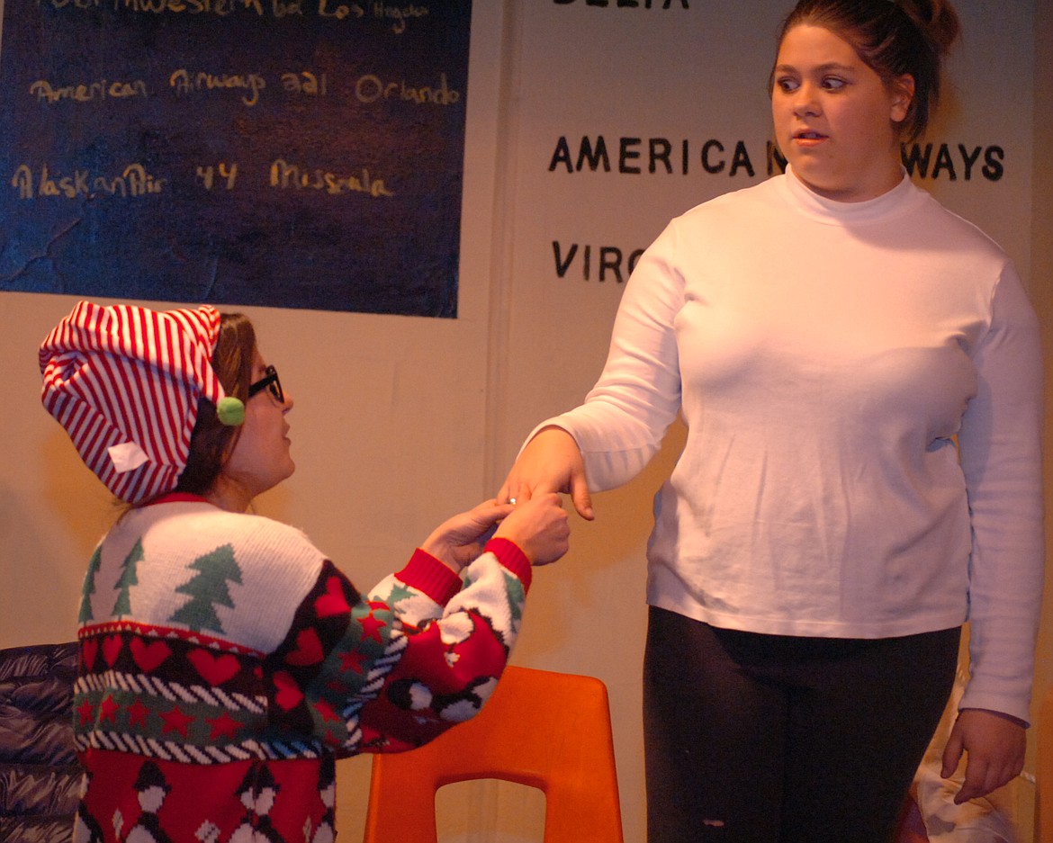 At left, Kevin Schneider, played by Grace Cockrell, askes the love of his life, Jenny Partridge, played by Leena Meckler, for her hand in marriage. Members of the Patridge and Schneider families were stranded at MRA Airport during a blizzard on Christmas Eve.