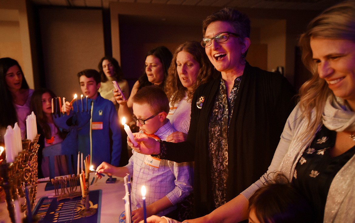 Rabbi Francine Roston leads the member of the Glacier Jewish Community &#151; B&#146;nai Shalom in the lighting of the  hanukkiah, the menorah candles with nine branches instead of the traditional seven at the Hanukkah celebration on Saturday night, Dec. 8, in Kalispell. (Brenda Ahearn photos/Daily Inter Lake)