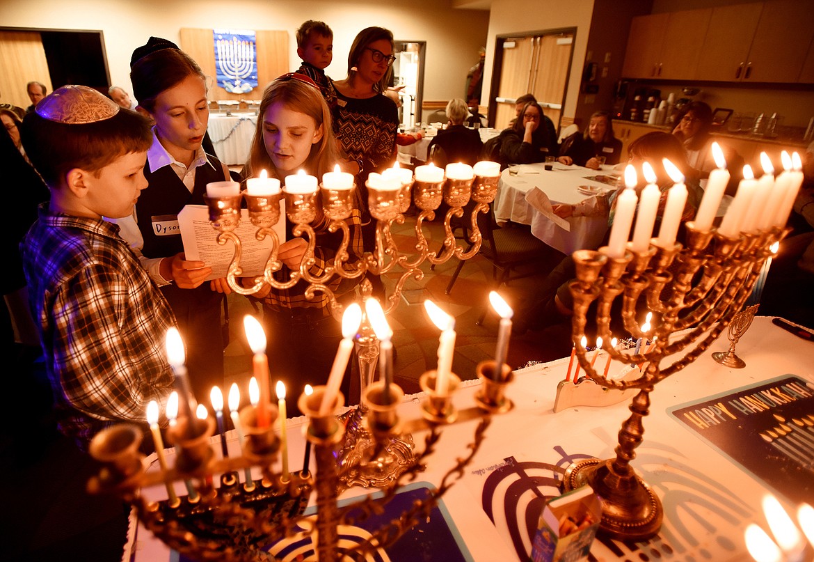 From left, Levi Edelen, 10, Dyson Linden, 12, and Joshua Edelen, 12, sing at the lighting of hanukkiah candles at the Glacier Jewish Community &#151; B&#146;nai Shalom Festival of Lights celebration on Saturday evening, December 8, in Kalispell.&#160;(Brenda Ahearn/Daily Inter Lake)