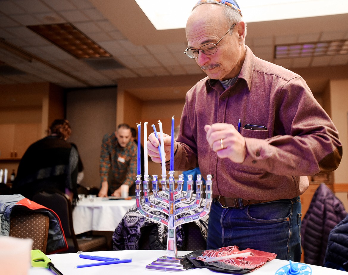 Jeff Sanders, of Whitefish, sets up his hanukkiah candle before the start of the Festival of Lights celebration with the Jewish community on Saturday, Dec. 8, in Kalispell. (Brenda Ahearn/Daily Inter Lake)