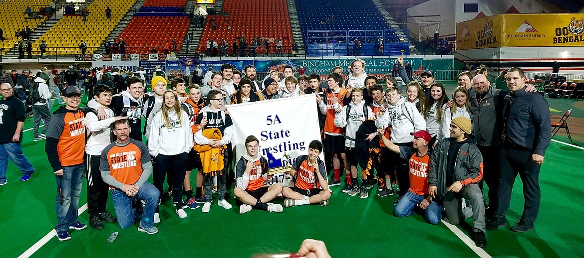 Photo courtesy ROBERT ROMERO
The Post Falls High wrestling team celebrates with the championship banner after winning the 5A title at the state wrestling championships at Holt Arena in Pocatello in February. Post Falls won with a state-record 338.5 points, nearly doubling the total of runner-up Bonneville (172.5) of Idaho Falls. The Trojans had 10 wrestlers in the finals and produced seven champions, en route to their third state title in four years.