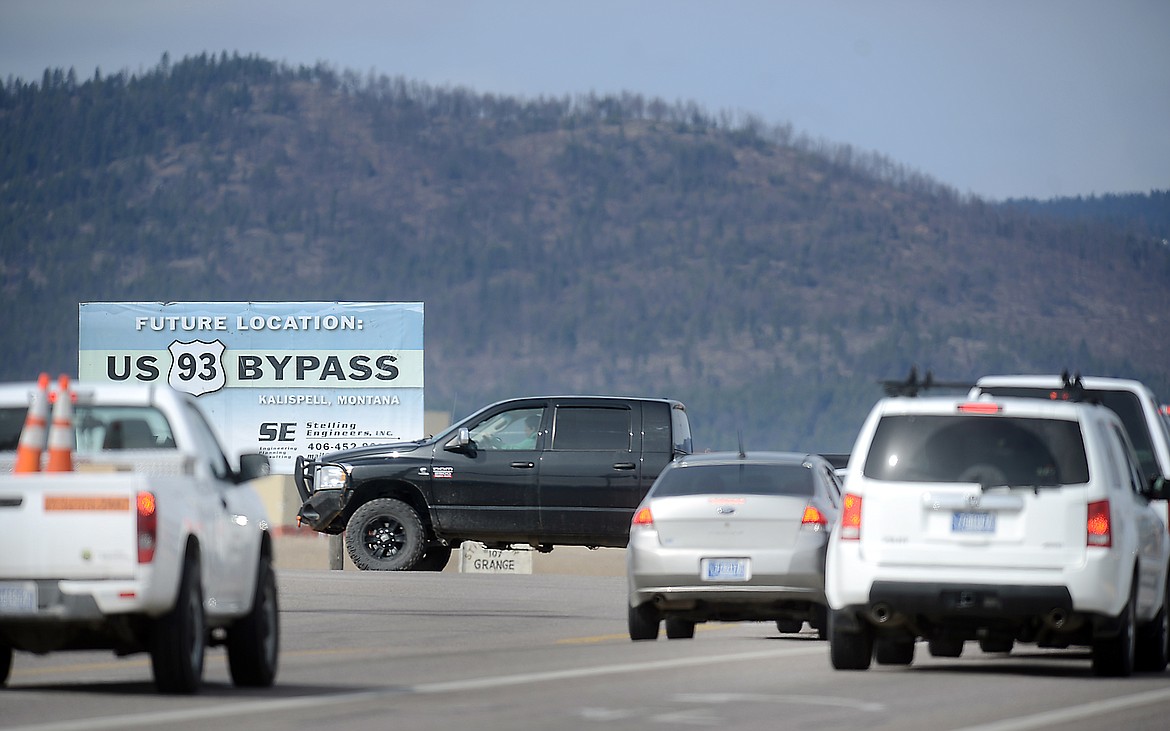 Traffic races through the intersection of West Reserve and U.S. 93 in Kalispell in 2013.  The bypass advertised in the sign above was completed in 2016. (Brenda Ahearn/Daily Inter Lake)