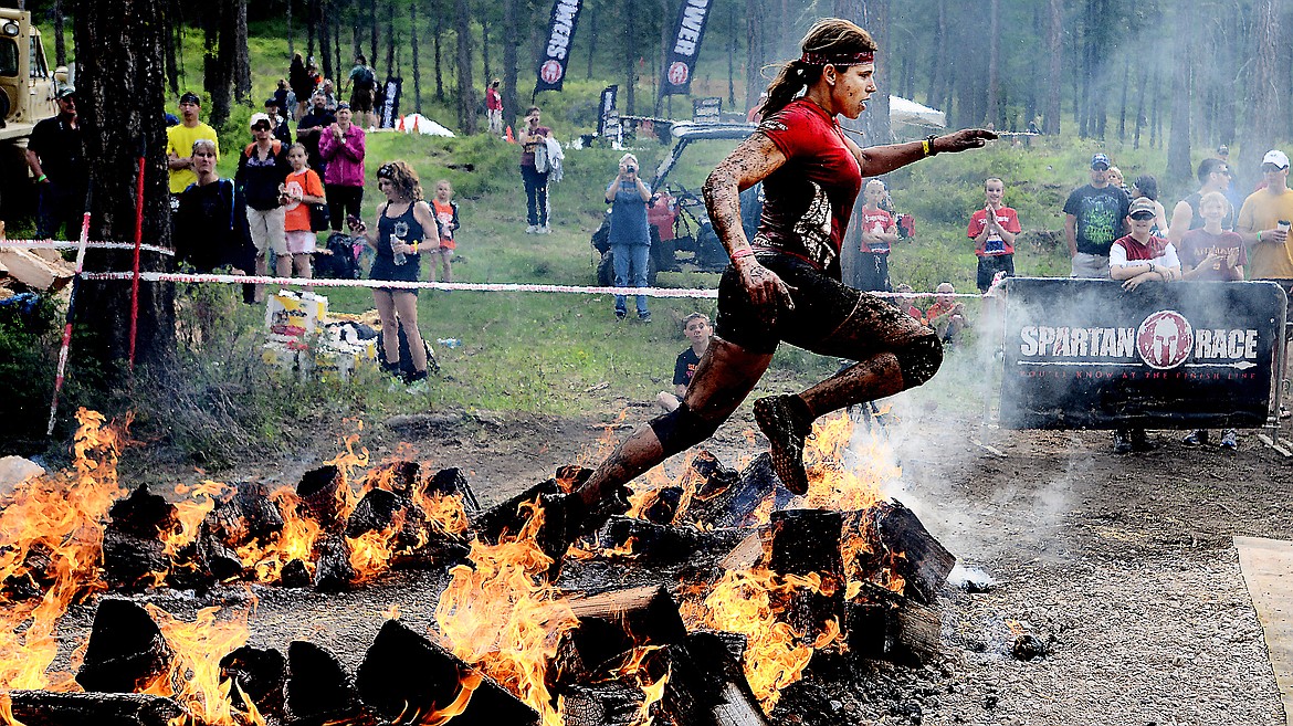 Juliana &quot;the Shark&quot; Sproles of Ojai, Calif., jumps over the Fire Jump as she nears the finish line on Saturday morning, May 11, 2015 at the Spartan Race in Bigfork.(Brenda Ahearn/Daily Inter Lake)