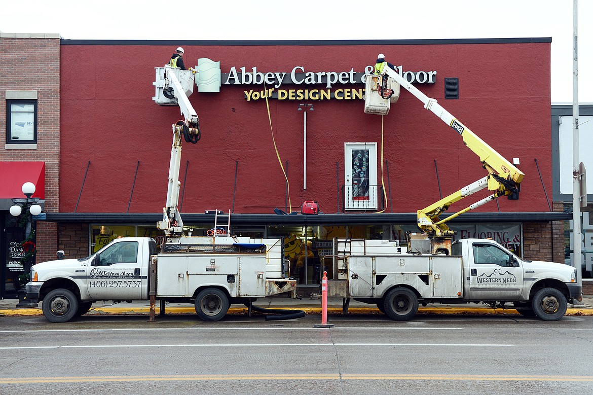 Workers with Western Neon hang a new sign over Roybal&#146;s Abbey Carpet &amp; Floor on South Main Street in Kalispell on Nov. 29. (Casey Kreider/Daily Inter Lake)