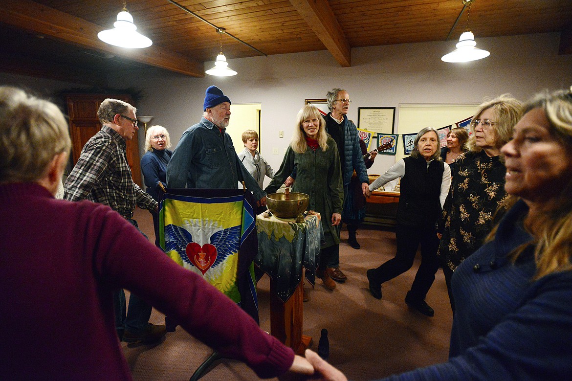 Attendees circle the room while singing, dancing and playing instruments at Dances of Universal Peace at Shining Mountains Center for Spiritual Living in Kalispell on Wednesday, Dec. 19. (Casey Kreider/Daily Inter Lake)