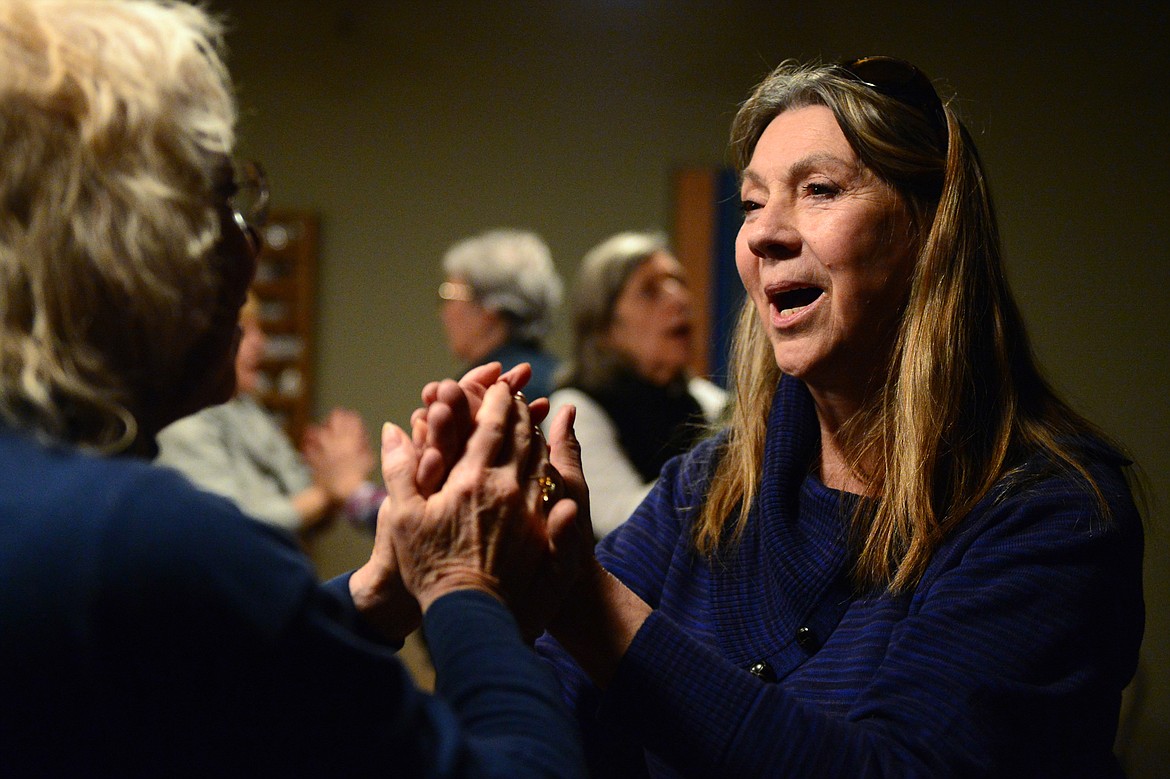 Rev. Yvonne Cottrell, senior minister and chief inspiration officer, holds the hands of a fellow dancer at Dances of Universal Peace at Shining Mountains Center for Spiritual Living in Kalispell.