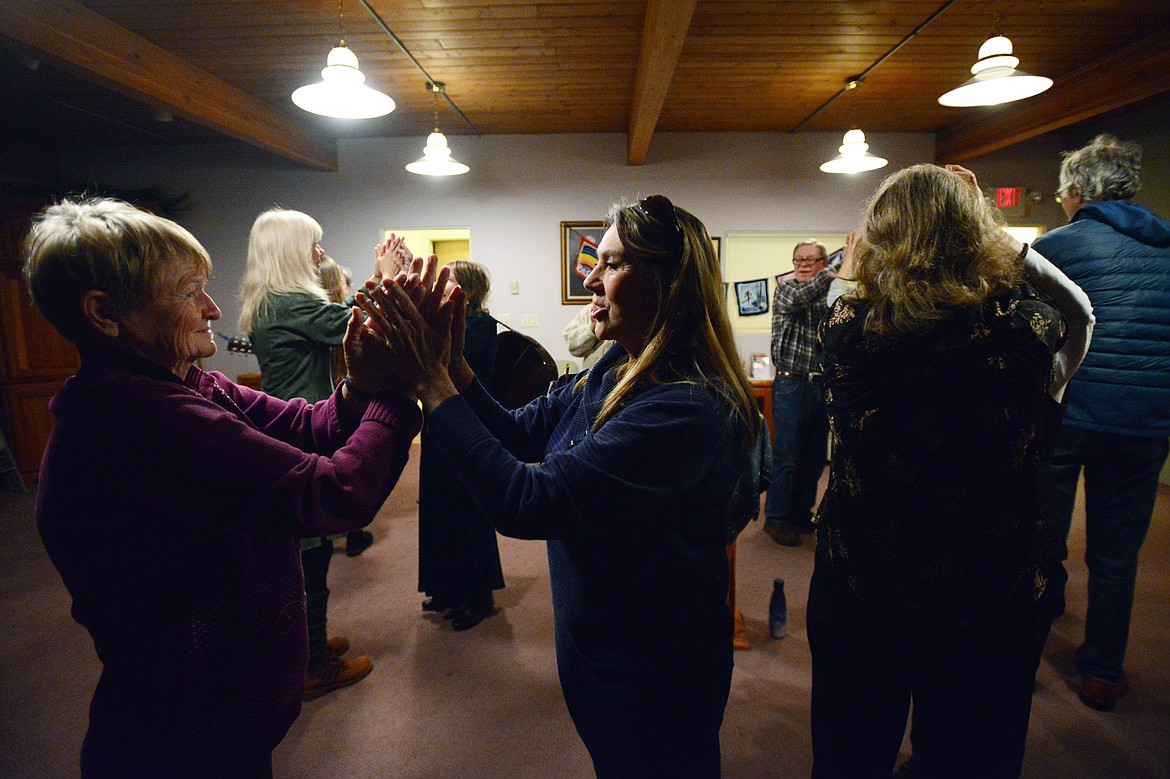 Rev. Yvonne Cottrell, right, senior minister and chief inspiration officer, holds the hands of a fellow dancer at Dances of Universal Peace at Shining Mountains Center for Spiritual Living in Kalispell on Wednesday, Dec. 19. (Casey Kreider/Daily Inter Lake)