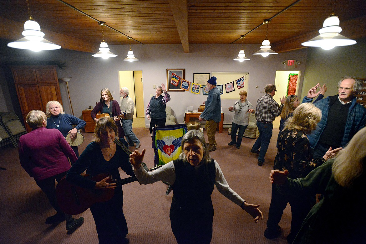 Attendees circle the room while singing, dancing and playing instruments at Dances of Universal Peace at Shining Mountains Center for Spiritual Living in Kalispell on Wednesday, Dec. 19. (Casey Kreider/Daily Inter Lake)