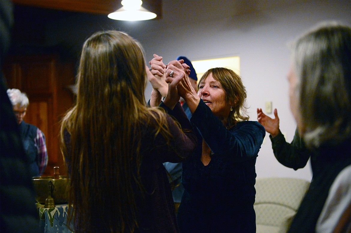 Carla Hannaford holds the hands of a fellow dancer at Dances of Universal Peace at Shining Mountains Center for Spiritual Living in Kalispell on Wednesday, Dec. 19. (Casey Kreider/Daily Inter Lake)