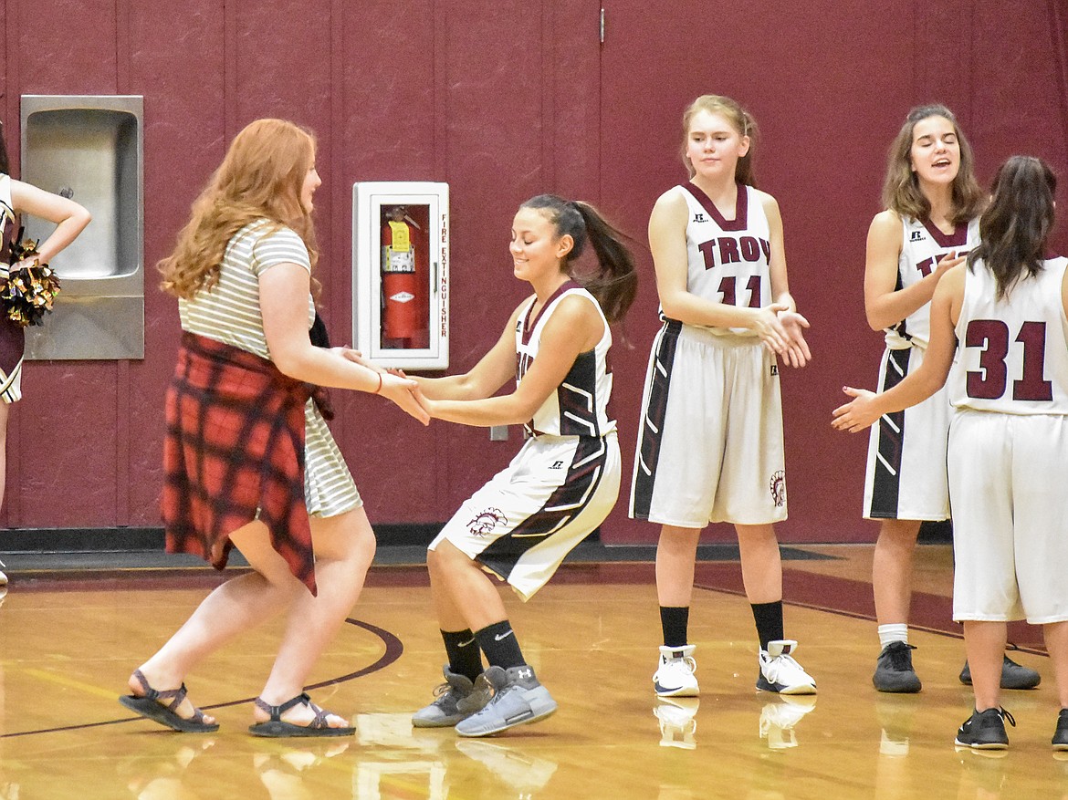 Troy junior Montana Rice gives "ten" to junior Isabel Ramirez. Though there to support her team, Rice has been benched by a shoulder injury. (Ben Kibbey/The Western News)