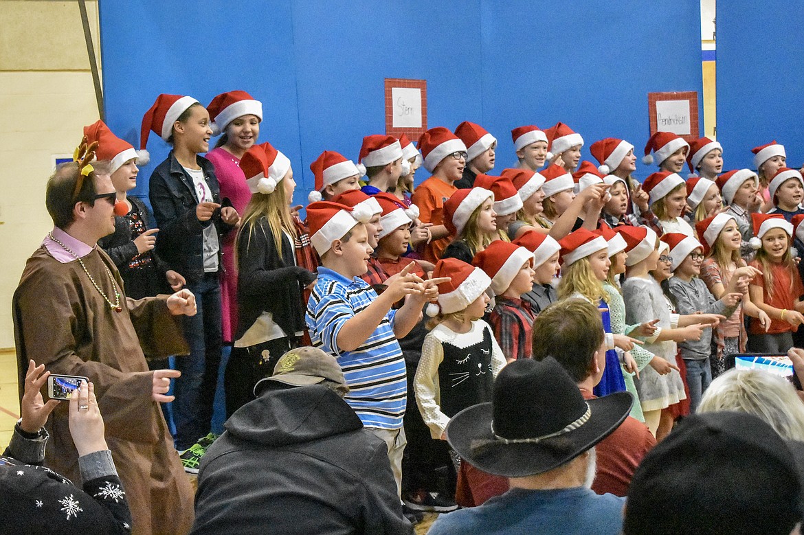 Libby Elementary School Assistant Principal and reindeer Andrew Stiger performs along with the 4th and 5th grade students during their Christmas concert at the Libby Elementary School gym Thursday. (Ben Kibbey/The Western News)