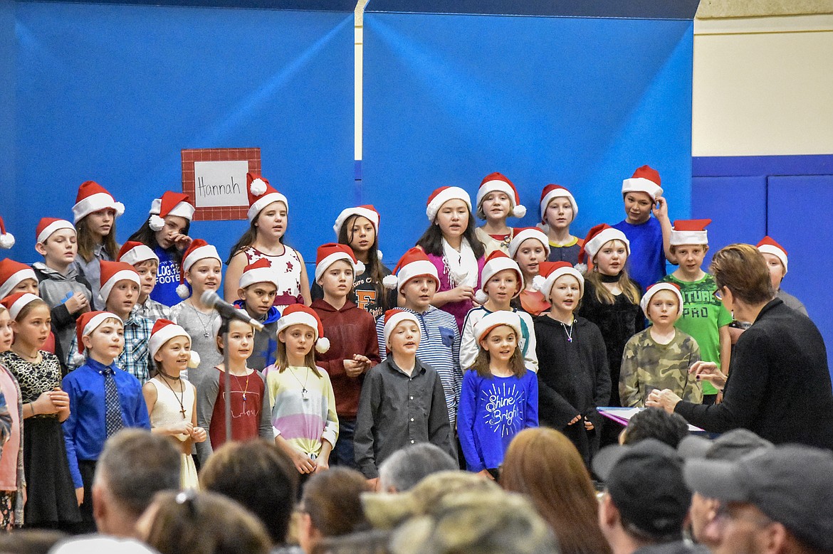 Libby Public Schools music teacher Lorraine Braun leads 4th and 5th grade students in song during their Christmas concert at the Libby Elementary School gym Thursday. (Ben Kibbey/The Western News)