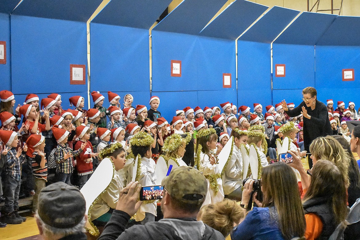 Libby Public School music teacher Lorraine Braun leads the kindergarten and 2nd grade students in song during their Christmas concert at the Libby Elementary School Gym Thursday. (Ben Kibbey/The Western News)