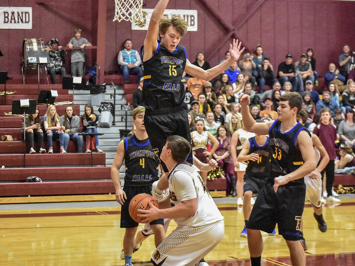 Thompson Falls senior Grant Lundberg adds some jump to his height, but it wasn't enough to keep Troy senior Alex Freund from scoring first quarter Friday. (Ben Kibbey/The Western News)