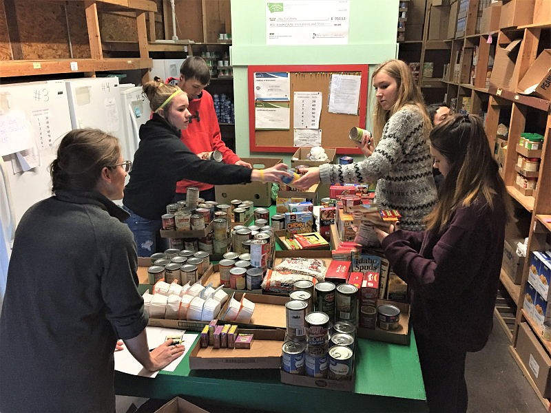 Troy Food Pantry Director Laura Finley, Katelyn Tallmadge, Dylan Cummings, Ella Pierce, Emily Ramirez (behind Pierce) and Chloe Phillips go through the items donated to the Troy Food Pantry through the Troy High School Honor Society. (Courtesy photo)