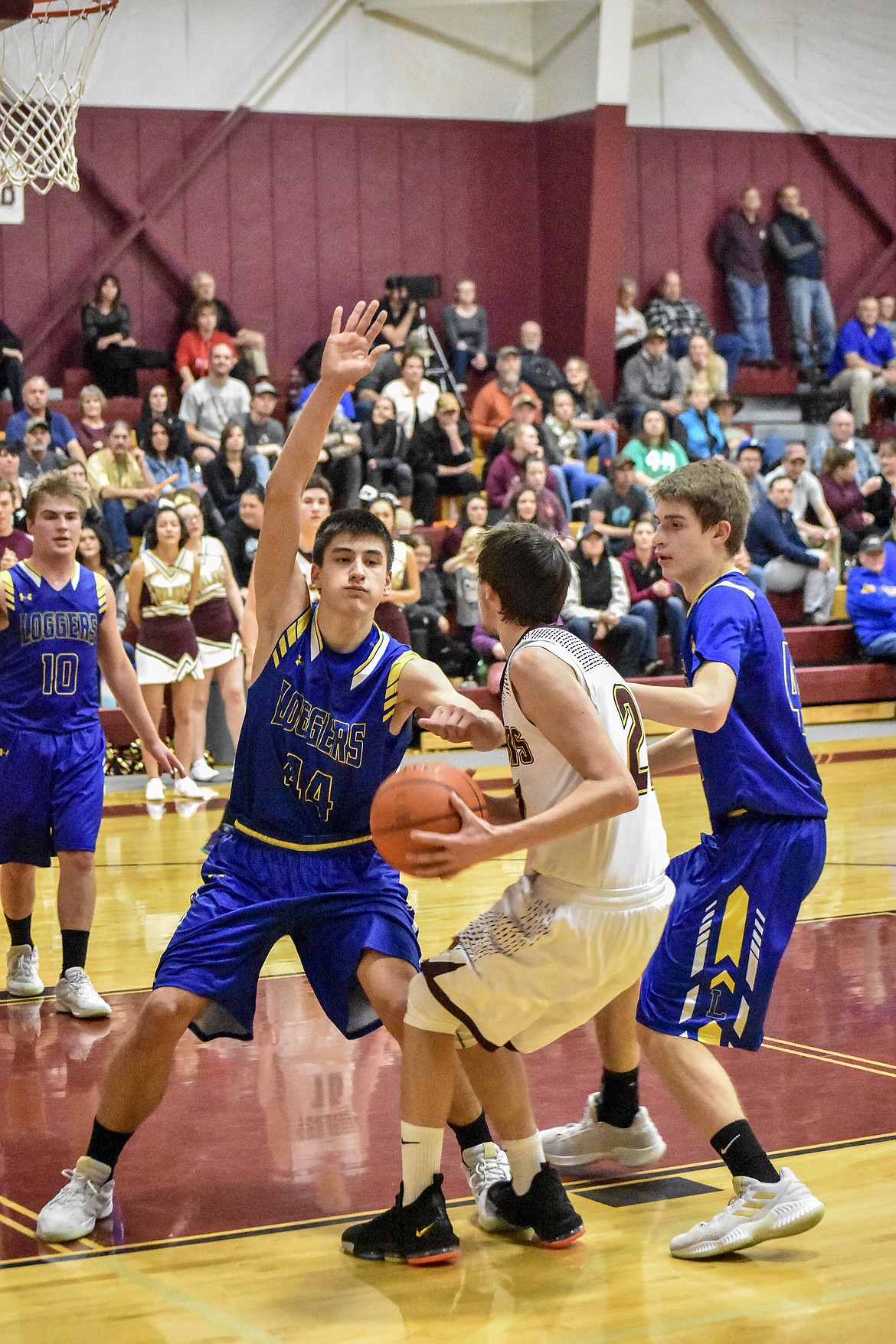 Flanked by Libby seniors Kevin Barnes and Tim Goodman, Troy senior Dylan Cummings looks for his shot before scoring in the second quarter at Troy Tuesday. (Ben kibbey/The Western News)