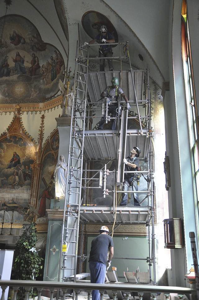 Crews from Grand Scaffolding lift a beam as they work to erect scaffolding at the St. Ignatius Mission Church Monday, July 30. (Ashley Fox/Lake County Leader)