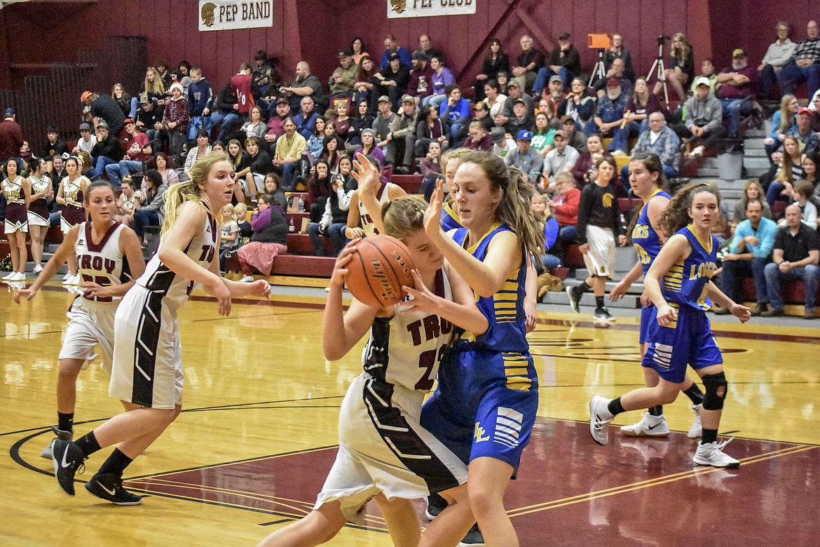 Troy junior Katelynn Tallmadge attempts to drive around Libby senior Jayden Winslow makes in the third quarter against at Troy Tuesday. (Ben Kibbey/The Western News)