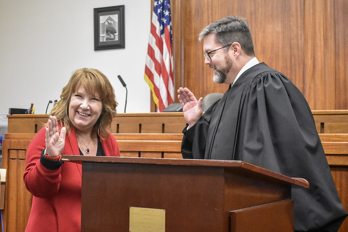 Montana 19th Judicial District Judge Matt Cuffe and Lincoln County Clerk and Recorder/Auditor/Assessor/Surveyor Robin Benson share a moment of levity at the length of her title during her swearing in at the County Courthouse Wednesday. (Ben Kibbey/The Western News)