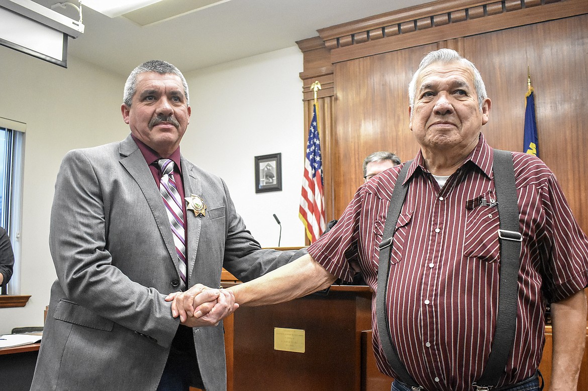 James Short congratulates his son, new Lincoln County Sheriff Darren Short, after pinning him with his badge at the County Courthouse Wednesday. Though the pinning would normally be done by outgoing Sheriff Roby Bowe, Bowe offered the honor to Short&#146;s father. (Ben Kibbey/The Western News)