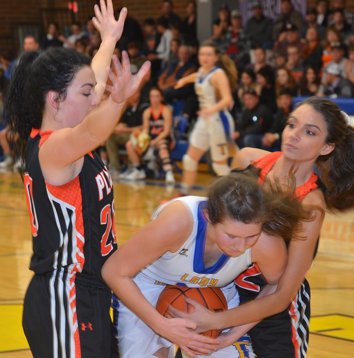 Thompson Falls sophomore Jody Detlaff is tied up by Meria Loberg of Plains during the Thursday, Dec. 20 game at Thompson Falls. Plains&#146; Haley Josephson also pressures Detlaff. The Lady Hawks rallied for a 47-41 victory. (Joe Sova photos/Clark Fork Valley Press)