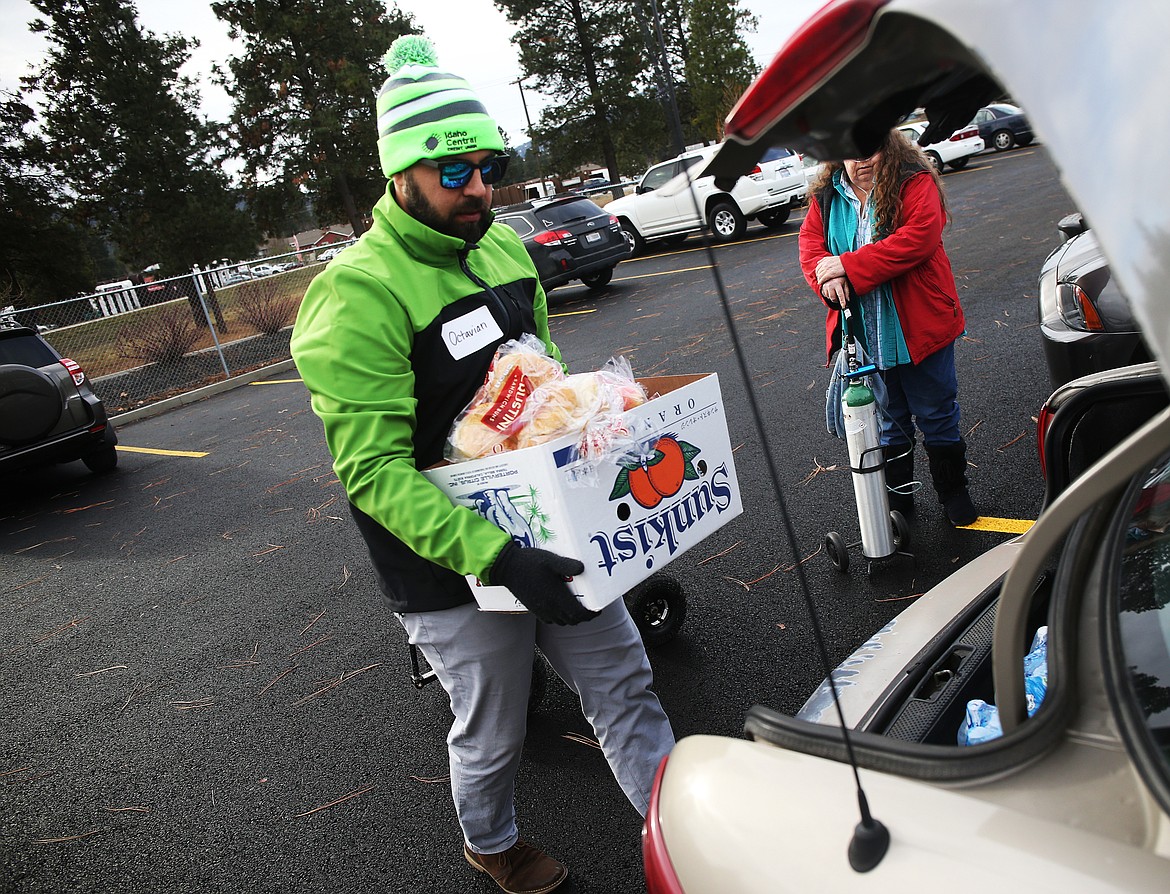 Volunteer Octavian Rivas with Idaho Central Credit Union helps load groceries. (LOREN BENOIT/Press)