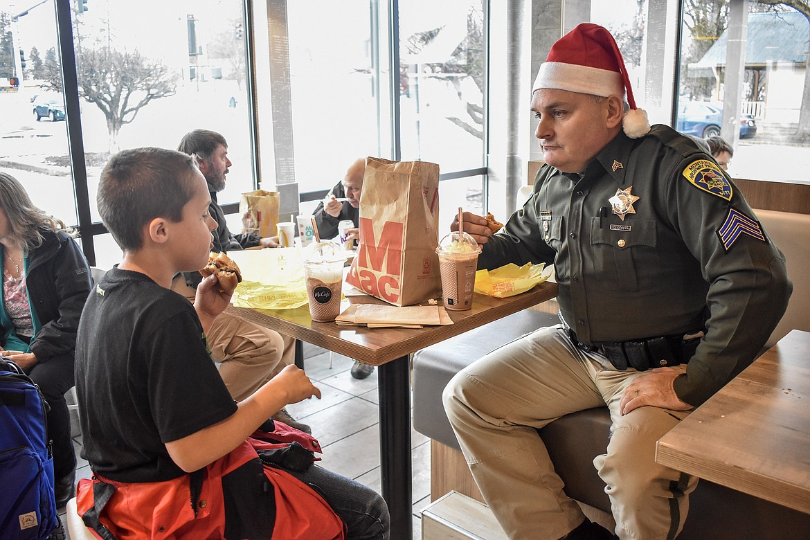 Eaddon Baca has lunch with Montana Highway Patrol Sgt. Neil Duram during Shop With a Cop in Libby. Baca said it had &#147;been forever&#148; since the last time he had a chocolate milkshake. (Ben Kibbey/The Western News)
