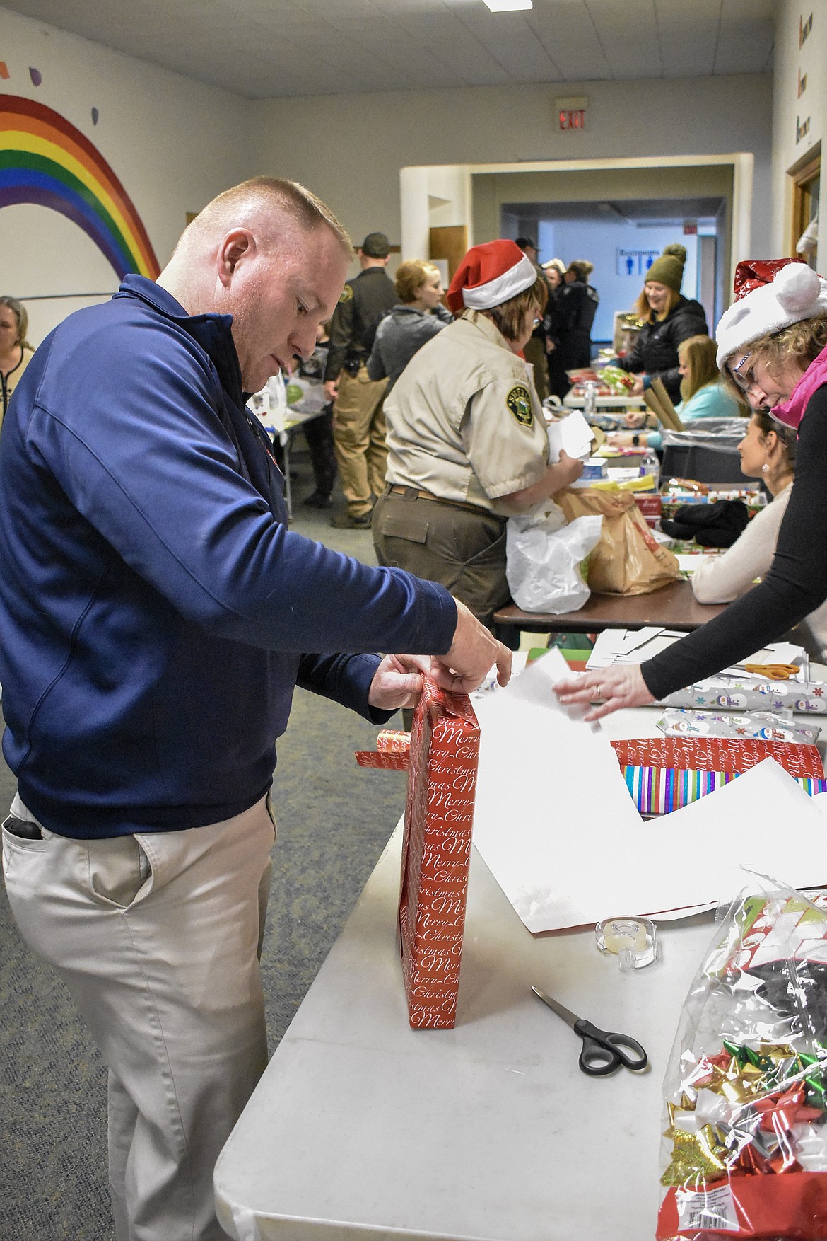 Libby Volunteer Fire Department Fire Chief Three Scott Beagle wraps presents during Shop With a Cop in Libby. (Ben Kibbey/The Western News)