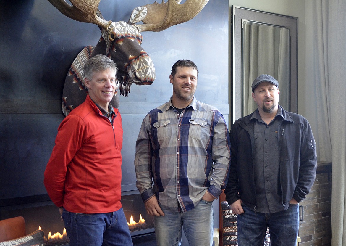 Bear Barinowski and Tyler Frank, with Malmquist Construction, and Kevin Richardson with Timber Forge Design, pose for a photo in the living room of the home. (Heidi Desch/Whitefish Pilot)