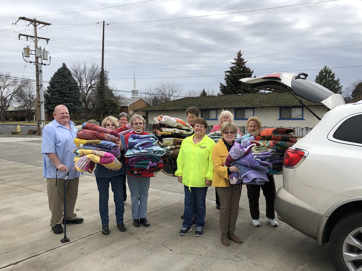 Fay Coats/courtesy photo - Quilters from Pilgrim Lutheran Church in Othello load quilts into Charlotte and Merritt Johnson's van. Volunteers distributed the quilts as needed when the community baskets were delivered.