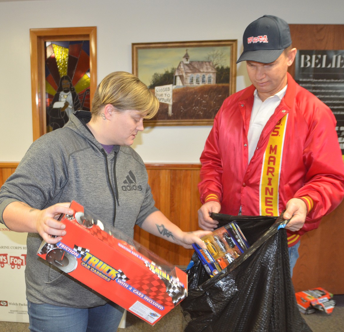 Kelli Hensley of Noxon selects toys from a wide array on display at Gospel Mountain Assembly of God Church during Toys for Tots distribution on Dec. 15 in Thompson Falls. Mike Dennison of Marine Corps League Detachment 1041 provides assistance.  Toys for Tots program on Dec. 15 at Gospel Mountain Assembly of God Church in Thompson Falls. (Joe Sova/Clark Fork Valley Press)